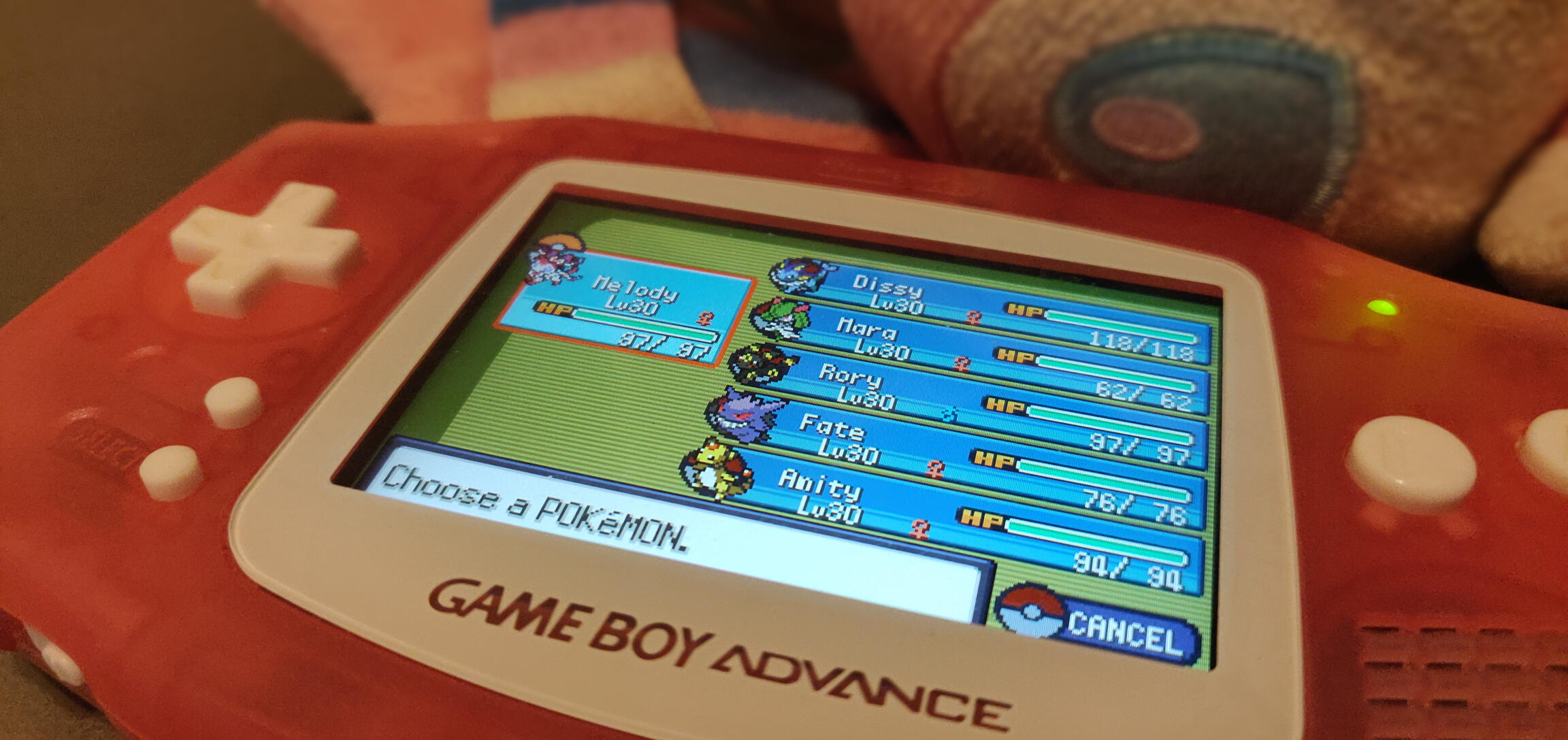 a pink Game Boy Advance with a modified screenshot of a 3rd-generation Pokémon game, showing a party of six level-30 pocket monsters: Melody (Sylveon), Dissy (Vaporeon), Mara (Kirlia), Rory (Umbreon), Fate (Gengar), and Amity (Ampharos).